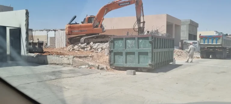 حفار وحاوية مخلفات في موقع هدم بالرياض